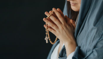 Téléchargez-les-photos-:-Gros-plan-de-la-Mère-de-Dieu-priant-en-tenant-un-chapelet---en-image-libre-de-droit