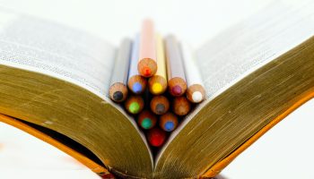Téléchargez-les-photos-:-Crayons-de-couleur-sur-une-bible.-Catéchisme.-Christian-curch.---en-image-libre-de-droit