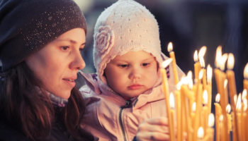 Mother and little blond Caucasian daughter in Church